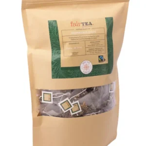 En forseglet teemballasjepose i gull merket "FairTea Moroccan Mint" med synlige teposer gjennom et klart vindu.