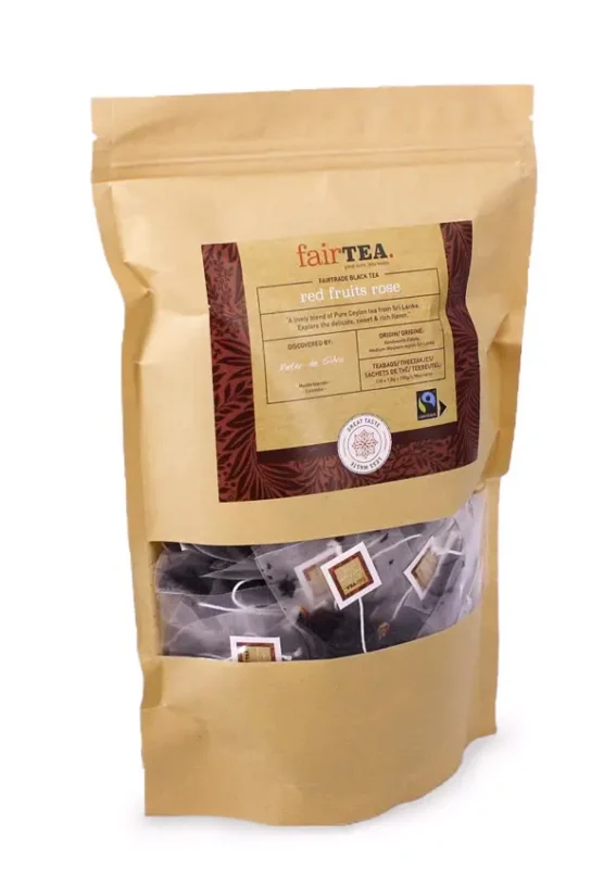 En pose med FairTea Red Fruits Rose te, med et klart vindu som viser teposer inni.