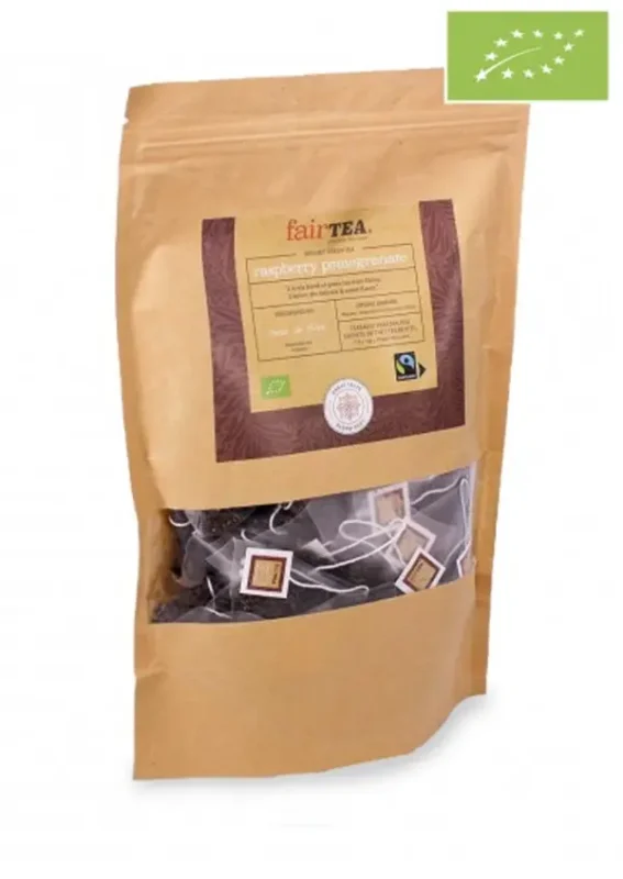 Brun papirpakke med "FairTea Raspberry Pomegranate" merket te med et gjennomsiktig vindu som viser løse blader, merket med sertifiseringer og en produktbeskrivelse.