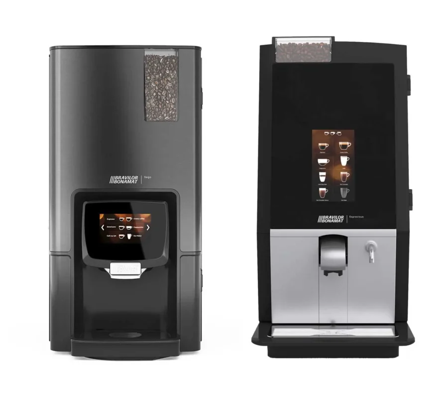 To moderne kaffemaskiner egnet for forretningsbruk, med innebygde digitale skjermer og bønnebeholdere, en svart og en sølv, isolert på hvit bakgrunn.
