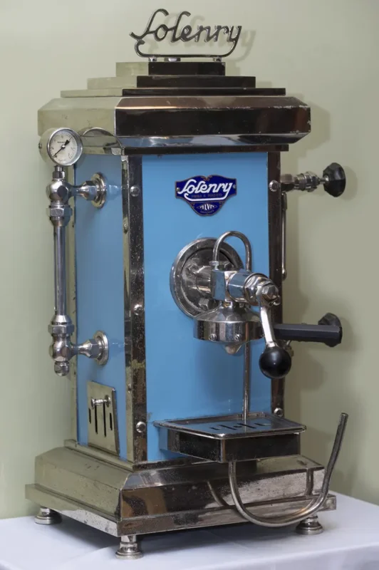 En vintage, blå og sølv espressomaskin med en trykkmåler og en "Lolenny"-logo foran, satt mot en lys bakgrunn—perfekt for enhver som vet at en god kaffemaskin øker produktiviteten.