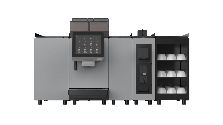Stor kaffemaskin for profesjonelt bruk med berøringsskjerm, flere rom og en koppdispenser på høyre side, avbildet mot en ensfarget hvit bakgrunn.
