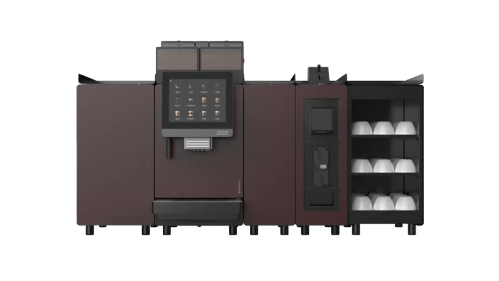 En profesjonell kaffemaskin med berøringsskjerm, innebygd koppdispenser og flere oppbevaringsrom for forbruksvarer, avbildet mot en ensfarget bakgrunn.