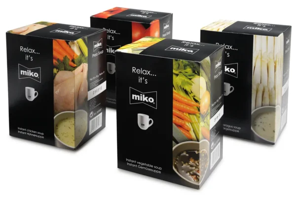 Tre bokser med øyeblikkelig suppe av merket Miko i forskjellige smaker: kyllingsuppe, grønnsakssuppe og nudelsuppe, ideell for en rask kveldsmat eller lunsj på kontoret, utstilt på en hvit